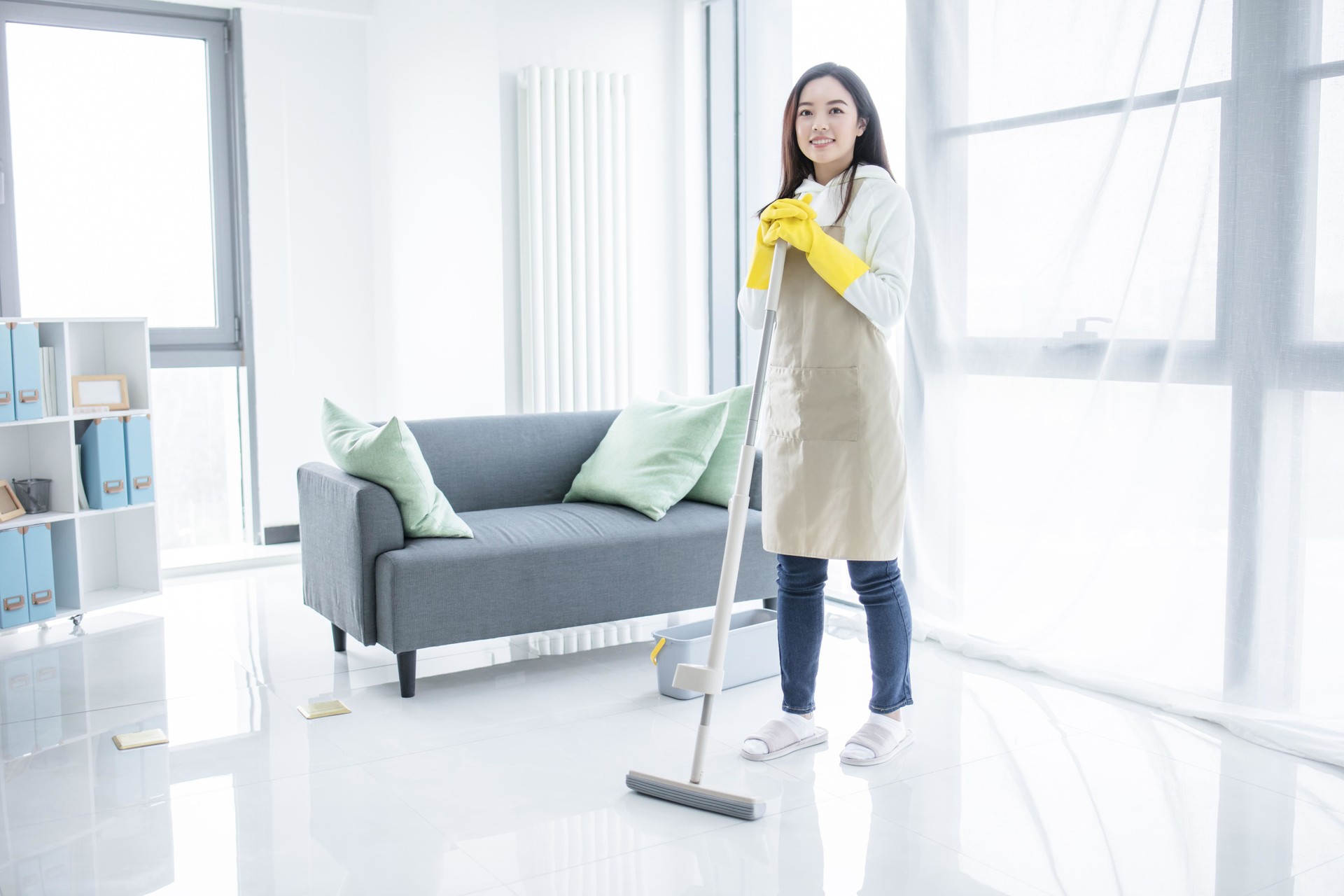 Asian woman mopping floor with mop